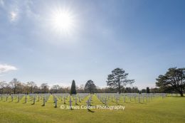 Sun shining over grave stones at Normandy American Cemetery, France