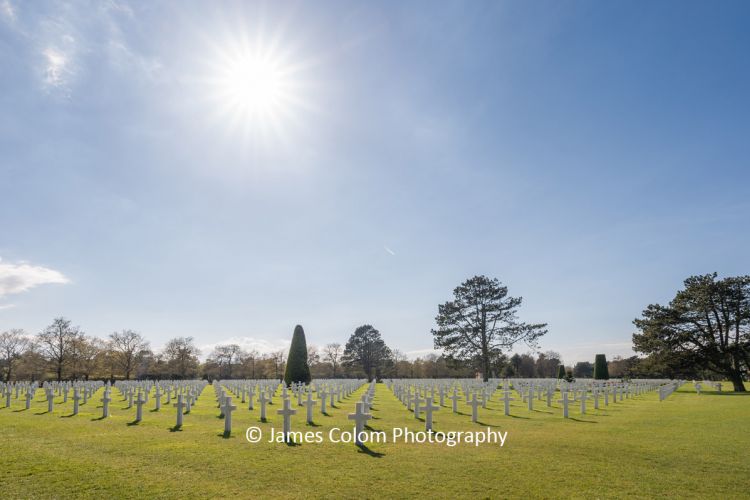 Sun shining over grave stones at Normandy American Cemetery, France